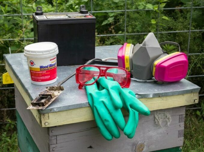 Hive box with work gloves, goggles, a dust mask, on top.